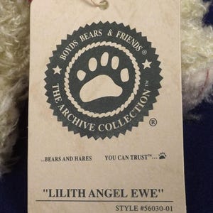 Puede incluir: Una etiqueta crema con el texto "BOYDS BEARS & FRIENDS" y "THE ARCHIVE COLLECTION". La etiqueta tambi&eacute;n dice "LILITH ANGEL EWE" y "STYLE #56030-01". Una cinta roja est&aacute; unida a la etiqueta.