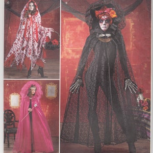 May include: Simplicity sewing pattern number 1029 for three Halloween costumes: a red hooded cape with white floral print, a black hooded cape with lace trim, and a pink hooded cape with a white trim. The pattern is for one size.
