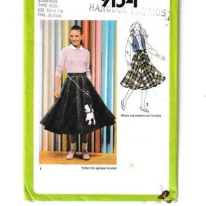May include: Simplicity pattern 9154, a vintage sewing pattern for a skirt with an appliqué poodle. The package contains two sizes, 5/6 & 7/8, and is from Hancock Fabrics. The pattern also includes a drawing of a woman wearing a plaid skirt.