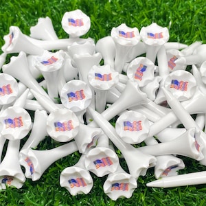 May include: A collection of white golf tees with a ruffled top and an American flag design.
