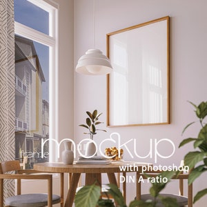 Puede incluir: Una mesa de comedor de madera con dos sillas, una lámpara colgante blanca, un marco de imagen y plantas. El marco de imagen está vacío y listo para una foto o una obra de arte. La mesa está puesta con un jarrón, libros y un cuenco de fruta.