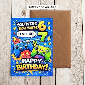 May include: A rectangular birthday greeting card featuring a blue background with yellow stars and lightning bolts. It displays two cartoon game controllers, one blue and one green, with the text: YOU WERE 6 NOW YOU'RE 7 LEVEL UP! HAPPY BIRTHDAY!