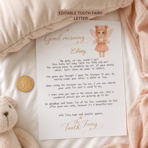 May include: A letter from the Tooth Fairy with a fairy illustration, addressed to "Ebony." The letter is on white paper with gold accents and includes a gold coin with a tooth design. The background includes a plush toy and soft fabric.