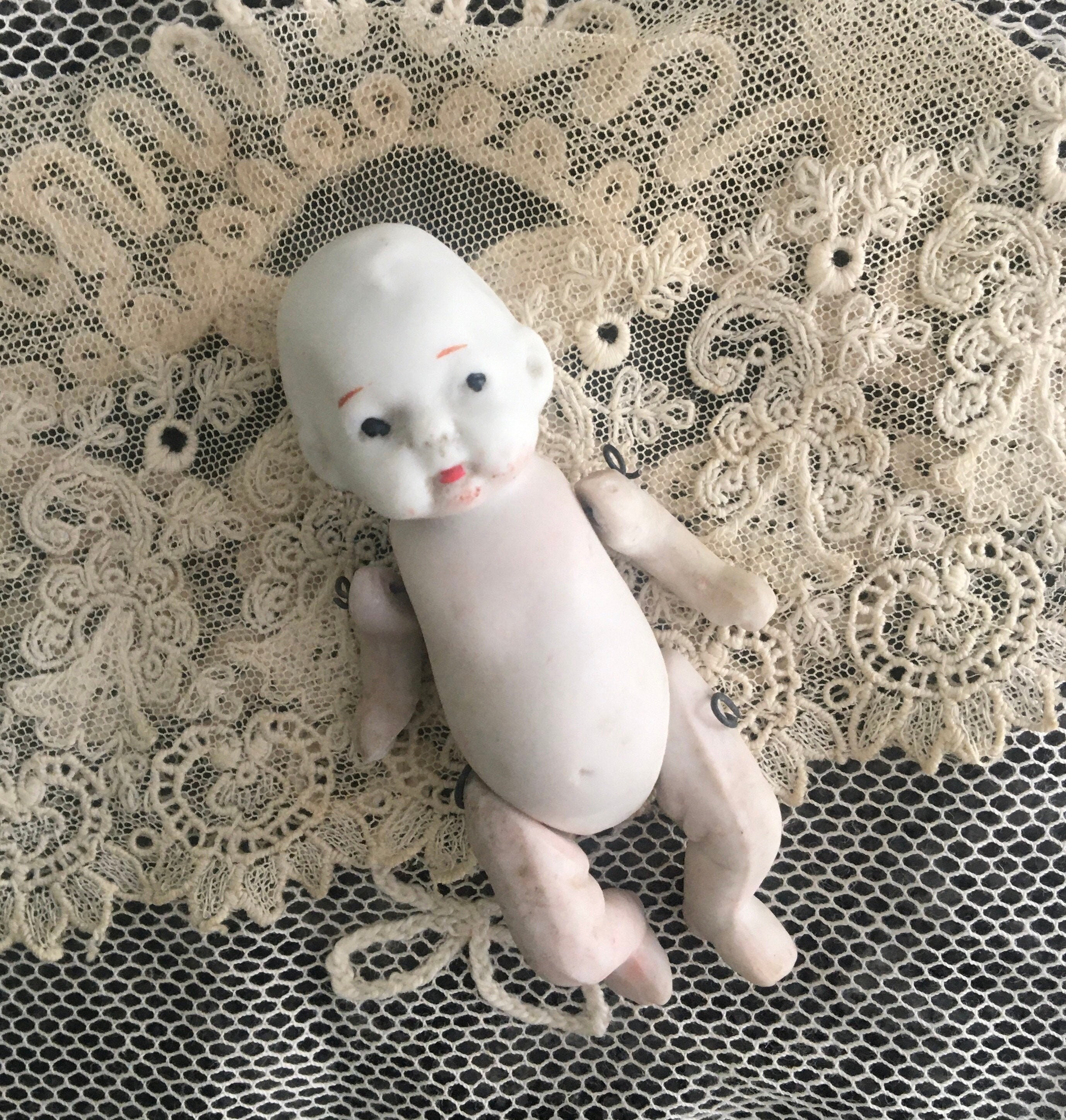 NAKA JAPANESE BABY GIRL BISQUE DOLL SITTING ON PILLOW