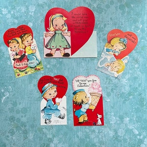 May include: A collection of vintage Valentine's Day cards. The cards feature heart shapes and illustrations of children and animals. Text includes phrases like "I like you" and "Be my Valentine!"