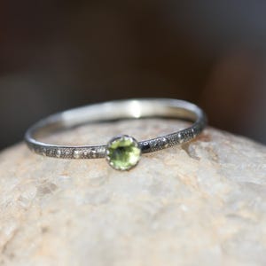 May include: A set of three ceramic mugs with a speckled, matte finish. The mugs are in shades of cream, light gray, and dark gray. Each mug has a simple, minimalist design and a rounded handle.