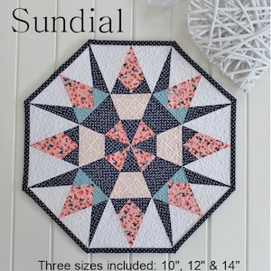 Può includere: Modello di trapunta Sundial con un design a stella a raggiera in tessuto floreale blu navy, bianco e rosa. Tre dimensioni incluse: 10", 12" e 14".