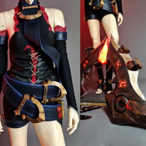 May include: A cosplay costume featuring a black top with red lacing and accents, paired with black shorts and a blue belt with gold-colored details. The costume includes a large, ornate brown and red leg armor piece with glowing accents.