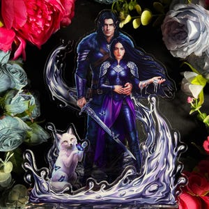 May include: An acrylic stand with a fantasy theme, depicting a couple in dark blue and purple clothing, holding a sword. A white fox with blue butterflies is also shown. The stand has a water-like design and floral decorations.