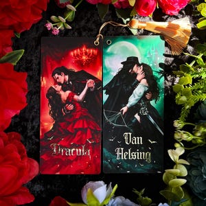 May include: Two rectangular bookmarks featuring romantic illustrations. One depicts a couple dancing with the word "Dracula", the other shows a couple kissing with the words "Van Helsing". Both have a hole at the top for a tassel.