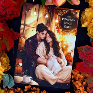 Peut inclure: Une impression d'art rectangulaire illustrant deux personnes s'enlaçant tout en tenant un chat blanc. La scène comprend des citrouilles, des feuilles d'automne et un panneau indiquant THE PUMPKIN SPICE CAFE. Un mug blanc est au premier plan.
