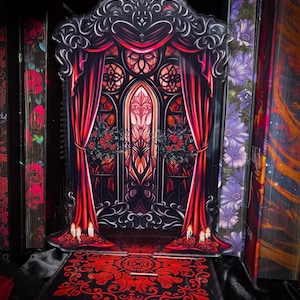 Puede incluir: Expositor g&oacute;tico de acr&iacute;lico, rojo y negro. Presenta un escenario con cortinas rojas, una vidriera y elementos florales decorativos. La base tiene un patr&oacute;n rojo a juego, creando una est&eacute;tica cohesiva.