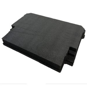 May include: A rectangular black foam insert with a textured, porous surface. The piece features specific cutouts along the edges, including a stepped section on one side and a notched corner, designed for protective storage or organisational purposes.