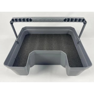 May include: A grey plastic storage bin with a U-shaped cutout in the front and a matching grey handle featuring the embossed text DECKED. The interior base of the bin is lined with a dark grey foam insert, providing a structured storage space.
