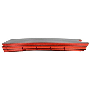 May include: A stack of rectangular foam sheets featuring alternating layers of black and bright orange. The sheets have a textured, grooved surface on the top and sides, with a slightly curved, flexible shape that appears layered and dense.