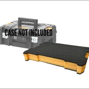 May include: Black and yellow foam insert for a tool case. The insert is rectangular with a black top and yellow sides. The tool case in the background is black with a handle and the text "CASE NOT INCLUDED".