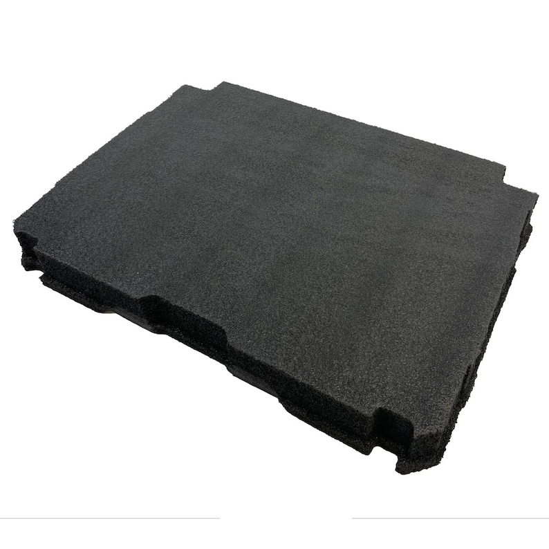 May include: A rectangular black foam insert with a textured surface and specific cutouts along the edges. The material appears porous and dense, designed for protective storage or organisation, featuring a flat top and a structured, moulded shape.