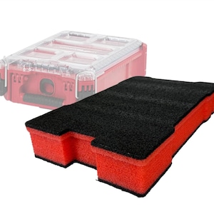 May include: A red and black foam insert for a tool box. The insert is rectangular with a black top and red sides. A red tool box with a clear lid is in the background.