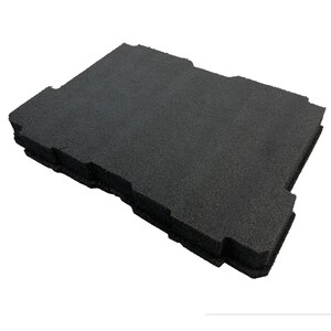 May include: A rectangular black foam insert with a textured surface and notched edges. The object features a layered construction with a porous, matte finish, designed with specific cutouts along the perimeter to fit into a larger container.