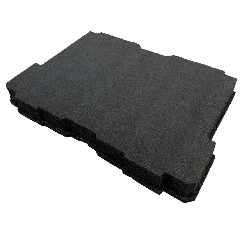 May include: A rectangular black foam insert with a textured surface and notched edges. The object features a layered construction with a porous, matte finish, designed with specific cutouts along the perimeter to fit into a larger container.