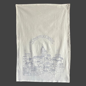 May include: A white cotton tea towel with a blue outline of a cityscape and the text "DERUTA A.D. 1475".