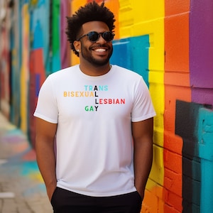 May include: A white t-shirt with the words "TRANS", "BISEXUAL", "LESBIAN", and "GAY" spelled out in a colorful criss-cross pattern.