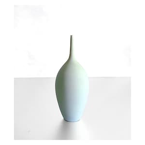 May include: A tall, light blue vase with a slender neck and a rounded body. The vase has a smooth, matte finish and a minimalist design. The vase is approximately 12 inches tall, perfect for displaying flowers or as a decorative accent.