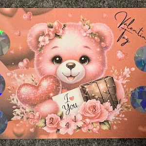 Könnte beinhalten: Eine Valentinstagskarte mit einem rosa Teddybären mit Blumenkrone, der ein Herz und eine Geschenkbox hält. Die Karte trägt den Text "I Love You" und "Valentines Tag". Dekorative holografische Kreise sind über die Karte verstreut.