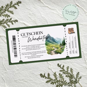 May include: A green gift voucher with the words "GUTSCHEIN FÜR EINEN Wandertrip" and a scenic mountain illustration. The voucher includes German text and a barcode. The voucher is for a hiking trip.