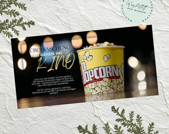 May include: A yellow popcorn bucket with the word "Popcorn" in red and white text. The bucket is filled with popcorn and sits in front of a dark background. The text "Surprise, We're going to the movies!" is also visible.