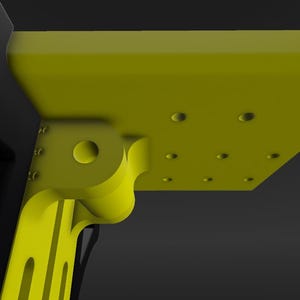 May include: A yellow plastic bracket with a series of holes and a rounded hinge. The bracket is attached to a black plastic piece.