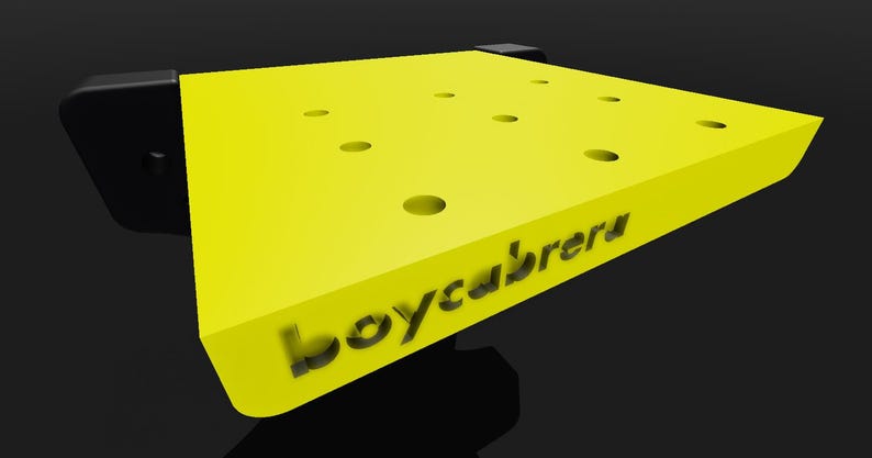 May include: A yellow, square-shaped workbench with multiple holes and the text "boycabretu" printed on the surface.