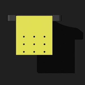 May include: A yellow sticky note with nine black dots hanging on a black hook.