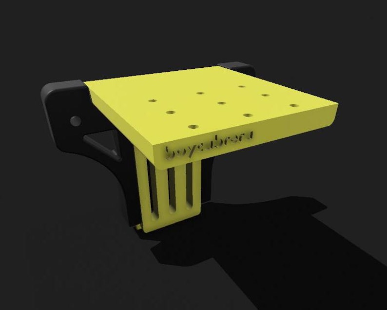 May include: A yellow plastic workbench with a black base and a label that says "boyabrend". The workbench has several holes drilled into the top surface.