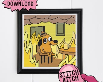 May include: A cross-stitch pattern featuring a cartoon dog sitting in a chair with a cup of coffee. The dog is surrounded by flames, and the text "This is fine" is visible in the background. The pattern is framed in a black frame.