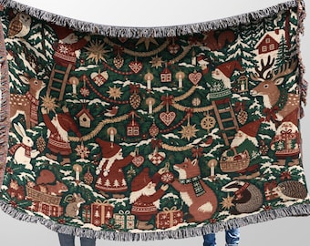 May include: A woven throw blanket featuring a dark green background with a festive holiday pattern. The design includes gnomes, deer, rabbits, squirrels, badgers, and hedgehogs decorating a Christmas tree with ornaments, candles, and gifts.