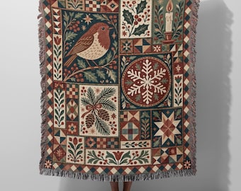May include: A woven throw blanket featuring a patchwork design with a robin, a snowflake, a lit candle, pinecones, and holly berries in shades of red, green, blue, and cream. The blanket has a fringed edge and a repeating diamond border.