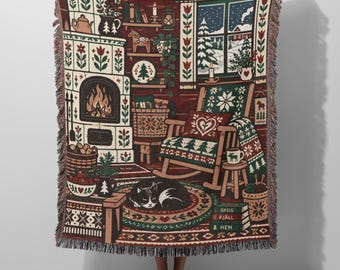 May include: A woven throw blanket featuring a cosy winter scene with a fireplace, a rocking chair, a sleeping black and white cat, and a window view of snow. The design includes shelves, a basket, and a stack of books labelled SKOG FJÄLL HEM.