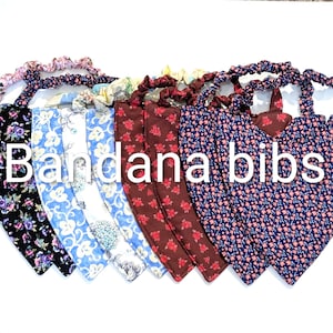 May include: A collection of bandana bibs in various floral patterns, including black with purple flowers, blue with white swirls, and red with small flowers. The text "Bandana bibs" is displayed in white.