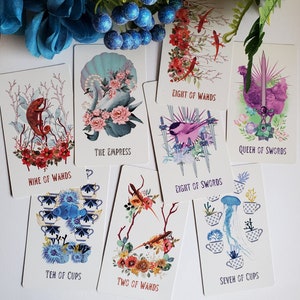 May include: A set of ten tarot cards with colorful illustrations and text. The cards include Nine of Wands, The Empress, Eight of Wands, Eight of Swords, Queen of Swords, Ten of Cups, Two of Wands, and Seven of Cups.