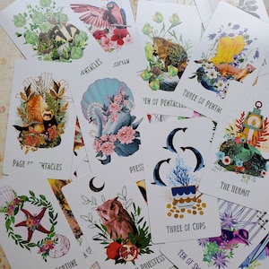 May include: A set of 10 tarot cards featuring colorful illustrations with various themes, including a mermaid, a hermit, a cup, and a pentacles. The cards are printed on thick cardstock with a matte finish.