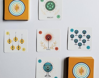 May include: A deck of square tarot cards with orange edges and white faces. The cards feature various symbols, including a star, a sunburst, and a chalice. The word "KNIGHT", "KING", and "PAGE" are printed on the cards.