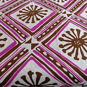 Puede incluir: Tela blanca con un patr&oacute;n repetido de flores estilizadas marrones en forma de diamante. El fondo es blanco con l&iacute;neas rosas y marrones.