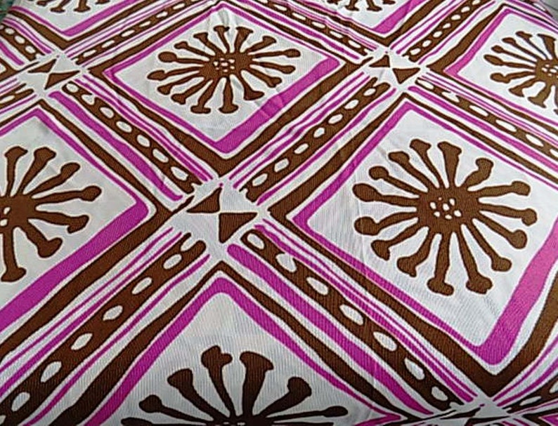 Puede incluir: Tela blanca con un patr&oacute;n repetido de flores estilizadas marrones en forma de diamante. El fondo es blanco con l&iacute;neas rosas y marrones.