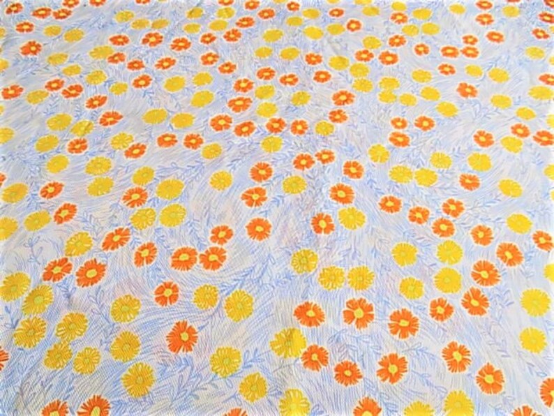 May include: A white fabric with a repeating pattern of yellow and orange flowers. The flowers are stylized and have a simple design.