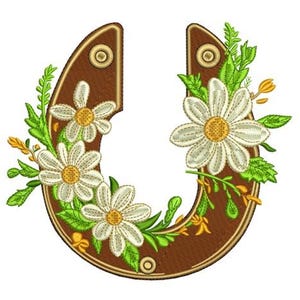 Könnte beinhalten: Gesticktes Hufeisen-Design in Braun mit weißen Gänseblümchen und grünen Blättern. Die Hufeisenform ist in einem dunkleren Braun umrandet, mit drei Gänseblümchen und anderen floralen Akzenten. Das Design hat ein rustikales, florales Thema.