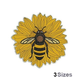 May include: Embroidered design of a bee in the center of a yellow sunflower. The bee has black and yellow stripes and brown eyes.