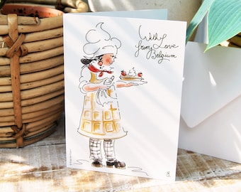 Puede incluir: Una tarjeta blanca con una ilustración de dibujos animados de un chef sosteniendo un plato de gofres con crema batida y fresas. El texto "With love from Belgium" está escrito en cursiva negra en la tarjeta.