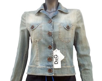 May include: A light blue denim jacket with a brown button closure and two front pockets. The jacket has a D&G Dolce & Gabbana tag attached.