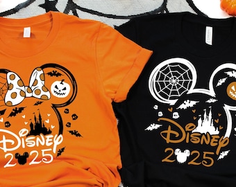 May include: Two Halloween themed t-shirts with a Mickey Mouse silhouette. The orange shirt has a bow and a pumpkin on the ear. The black shirt has a spiderweb and a pumpkin on the ear. Both shirts say "Disney 2025" with a Mickey Mouse head.